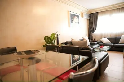 a living room with a glass table and a couch at Appartement moderne en plein centre de l'Agdal in Rabat