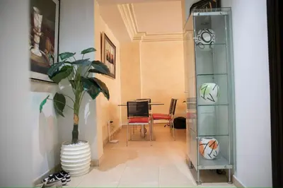 a living room with a table and a potted plant at Appartement moderne en plein centre de l'Agdal in Rabat