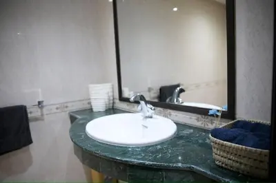 a bathroom with a sink and a large mirror at Appartement moderne en plein centre de l'Agdal in Rabat