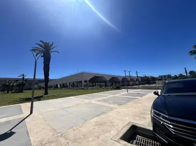 a car parked in a parking lot with a palm tree at Appartement moderne en plein centre de l'Agdal in Rabat
