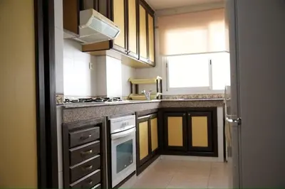 a kitchen with a sink and a stove top oven at Appartement moderne en plein centre de l'Agdal in Rabat