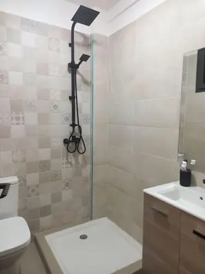 a bathroom with a shower and a toilet and a sink at Appart familial près de la plage Val d'or in El Harhoura