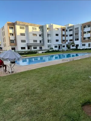 a large apartment building with a large swimming pool at Appart familial près de la plage Val d'or in El Harhoura