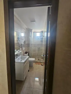 a bathroom with a toilet and a sink and a shower at Appartement proche de la mer de bouznika in Bouznika