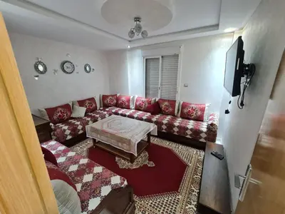 a living room with a couch and a table at Appartement perle de bouznika in Kasba Bou Hamira