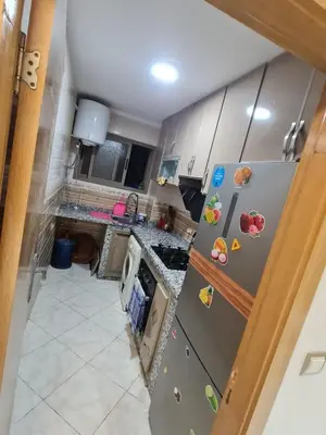 a kitchen with a refrigerator with magnets on it at Appartement perle de bouznika in Kasba Bou Hamira