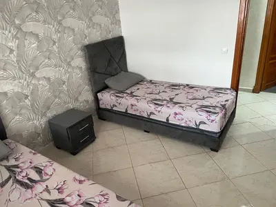 a small bed sitting in a room next to a wall at Appartement Oasis beach in Pont Blondin