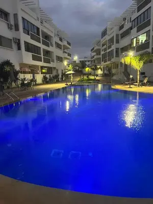 a large blue pool in front of a building at Appartement Oasis beach in Pont Blondin