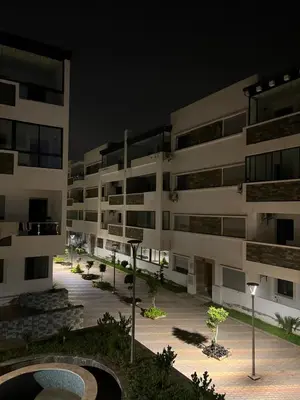 a large apartment building with a courtyard at night at Appartement Oasis beach in Pont Blondin