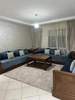 a living room with blue couches and a coffee table at Appartement Oasis beach in Pont Blondin