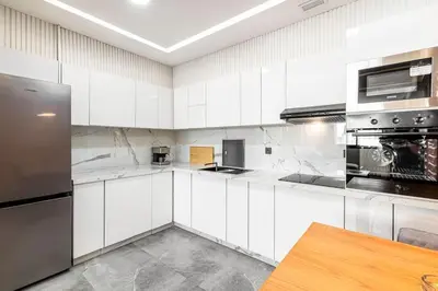 a kitchen with white cabinets and stainless steel appliances at Modern and Luxurious apartment in Rabat