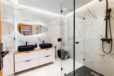 a bathroom with white marble walls and a shower at Modern Elegance in City Core in Gare de Rabat-Aguedal