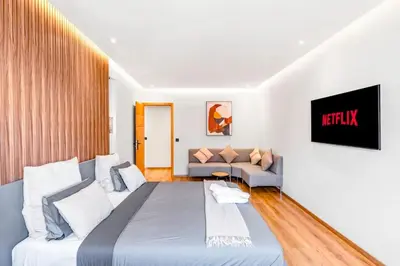a bedroom with a large bed and a couch at Modern Elegance in City Core in Gare de Rabat-Aguedal