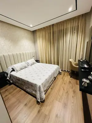 a bedroom with a bed and a table and a chair at Studio Al Amir 12 CFC à 2mn in Casablanca