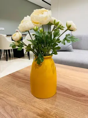 a yellow vase with white flowers on a table at Studio Al Amir 12 CFC à 2mn in Casablanca