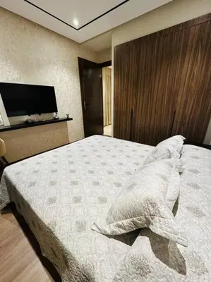 a bedroom with a large bed and a television at Studio Al Amir 12 CFC à 2mn in Casablanca
