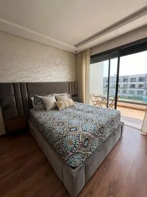 a bedroom with a bed and a large window at Studio Cosy avec Vue Piscine El Mansouria in Mansouria