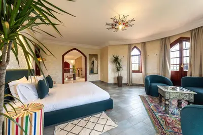 a bedroom with a bed and a living room at Bienvenue au Château Loriana ! in Bouznika
