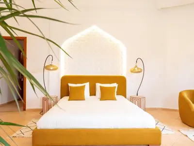 a bedroom with a bed with yellow pillows at Bienvenue au Château Loriana ! in Bouznika