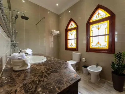 a bathroom with a sink and a toilet and a window at Bienvenue au Château Loriana ! in Bouznika