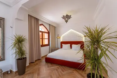 a bedroom with a bed and two potted plants at Bienvenue au Château Loriana ! in Bouznika