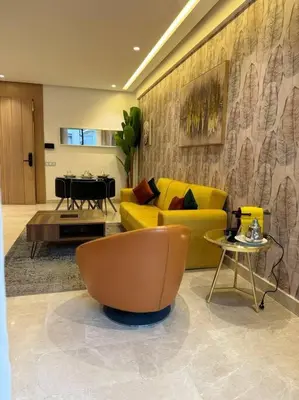 a living room with a yellow couch and a table at Little paradis Casablanca in Casablanca