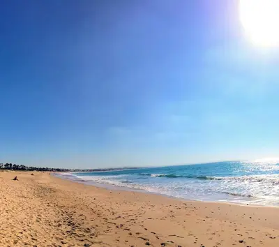 a beach with footprints in the sand and the ocean at Bel Appartement avec Piscine et Jardin, EL MANSOURIA in Mansouria