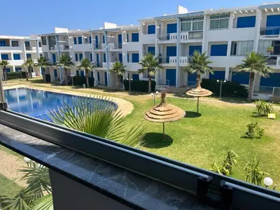 a view of the pool from the balcony of a building at Bel Appartement avec Piscine et Jardin, EL MANSOURIA in Mansouria