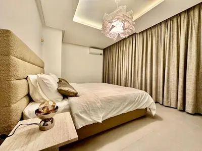 a bedroom with a bed and a chandelier at Appartement Luxueux Spacieux & une Vue Panoramique in Casablanca