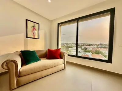 a living room with a couch and a large window at Appartement Luxueux Spacieux & une Vue Panoramique in Casablanca