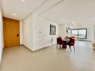 a dining room and living room with a table and chairs at Appartement Luxueux Spacieux & une Vue Panoramique in Casablanca
