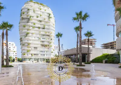 a tall building with palm trees in a parking lot at Les Tours Végétales, Casablanca Finance City in Casablanca