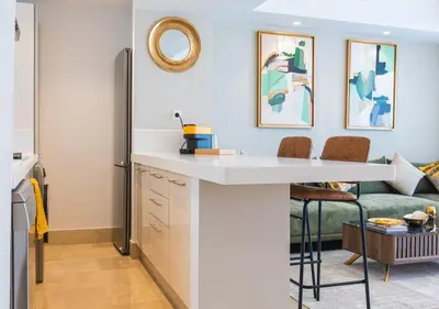 a kitchen with a white counter and a couch at Les Tours Végétales, Casablanca Finance City in Casablanca