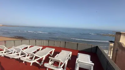 a group of white chairs sitting on the beach at surf trip in Kasba Bou Hamira
