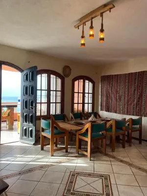 a dining room with a wooden table and chairs at surf trip in Kasba Bou Hamira