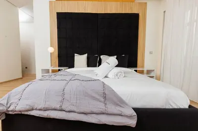 a bedroom with a large bed with white sheets and pillows at Elegant 2BR in Hay Riad - New Furnishings & Design in Beni Brour