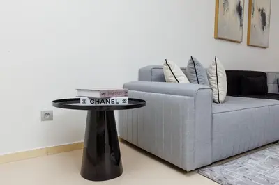a table in a living room next to a couch at Elegant 2BR in Hay Riad - New Furnishings & Design in Beni Brour