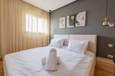 a bedroom with a white bed with a towel on it at Luxurious and modern 2BR with Stunning View in Beni Brour