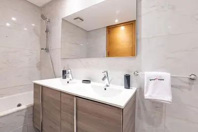 a bathroom with a sink and a mirror and a tub at Luxurious and modern 2BR with Stunning View in Beni Brour