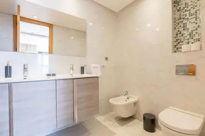 a white bathroom with a toilet and a sink at Luxurious and modern 2BR with Stunning View in Beni Brour