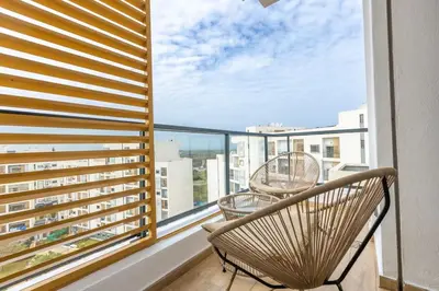 a balcony with two chairs and a large window at Luxurious and modern 2BR with Stunning View in Beni Brour