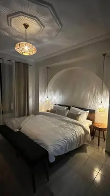 a bedroom with a large bed and a chandelier at Modern meets traditional ! in Casablanca