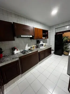 a kitchen with brown cabinets and a black refrigerator at Modern meets traditional ! in Casablanca