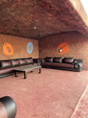 a living room with leather couches and a table at Casa Jnane Jawhara Skhirat in Rabat