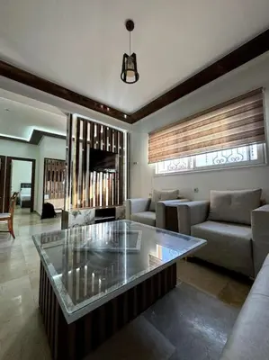 a living room with a couch and a glass table at Jnane Jawhara Skhirat house in Skhirat
