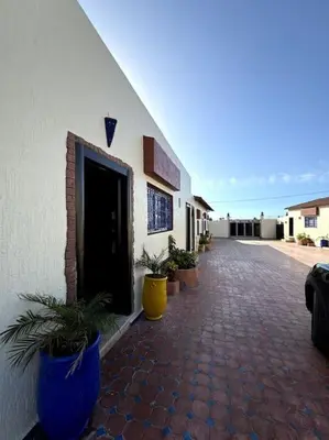 a building with potted plants sitting outside of it at Jnane Jawhara Skhirat house in Skhirat
