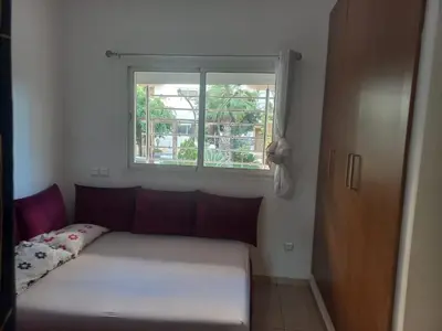 a bed sitting in a room with a window at vague bleue de bouznika in Bouznika