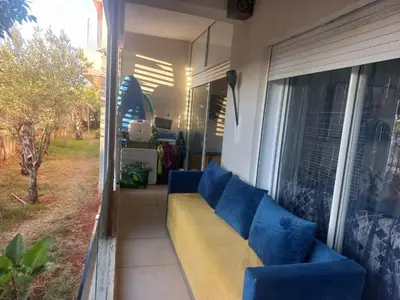 a couch sitting on the porch of a house at vague bleue de bouznika in Bouznika