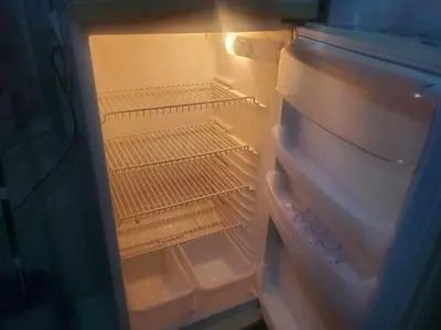 an empty refrigerator with its door open and itsartmentsearchangering at à 10 minutes du grand mall d'Afrique, WiFi Netflix 1ère étage in Oulad Hamida