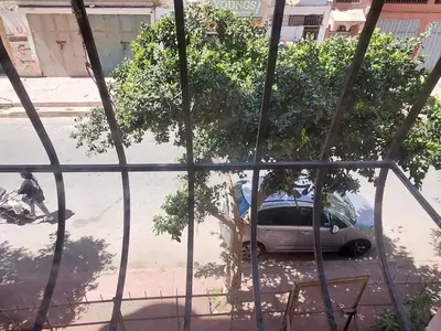 a car parked on the side of a street with a tree at à 10 minutes du grand mall d'Afrique, WiFi Netflix 1ère étage in Oulad Hamida